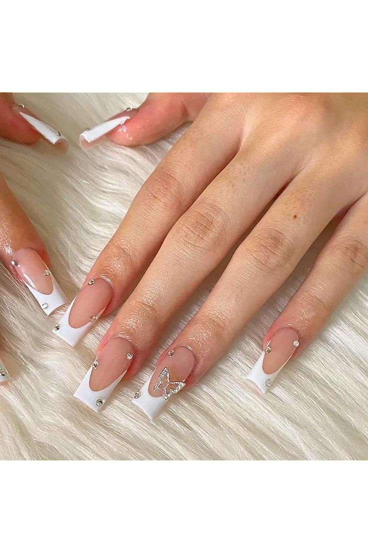 Sophisticated Nail Design with Clear Base, White Tips, Rhinestones, and Butterfly Accents.