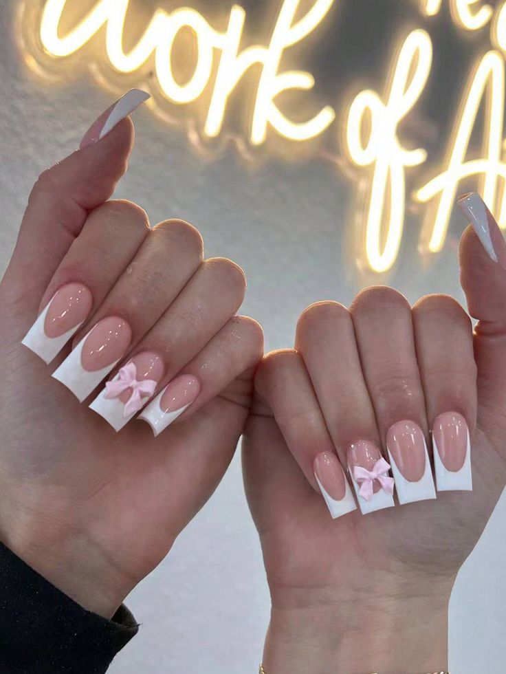 Chic Soft Pink and White Nail Design with Playful Bow Accents.