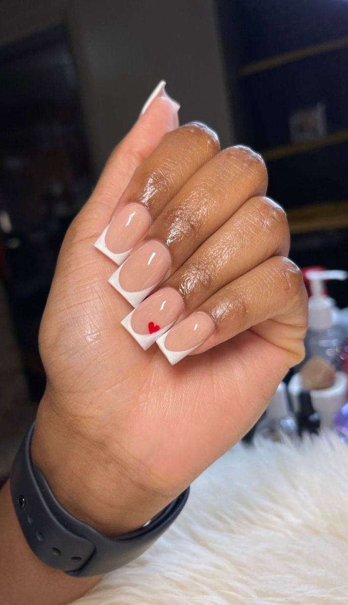 Stylish Nude-Base Nail Design with Chic White Tips and Playful Red Heart Accent