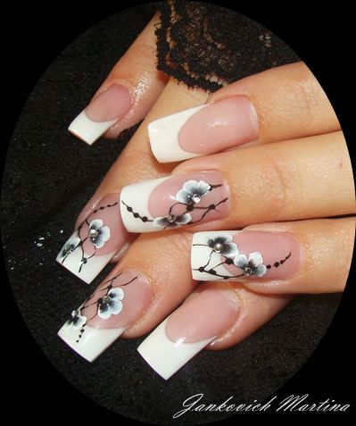 Sophisticated Nude and White Nail Design with Delicate Black Floral Accents.