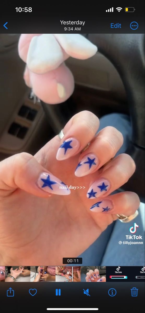 Whimsical Starry Nail Design: Soft Pink Base with Bold Blue Stars for Trendy Flair