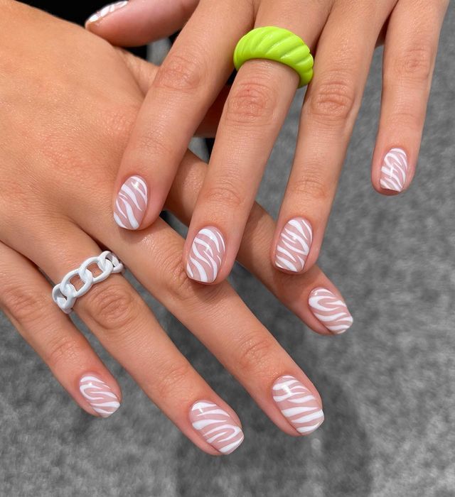 Chic Soft Pink Nail Design with White Stripes and Vibrant Accessories for a Trendy Look.