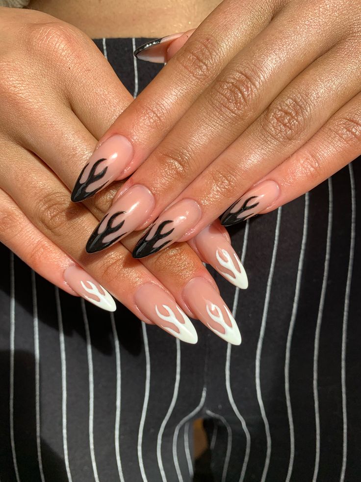 Bold Black and White Flame Nail Design on Nude Base with Almond Tips.