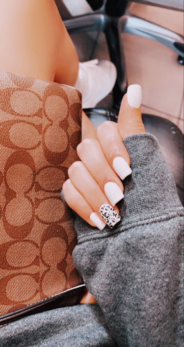 Chic White Nail Design with Trendy Leopard Print Accent.