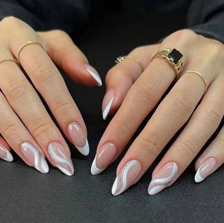 Chic Almond-Shaped Nails with Nude Base, White French Tips, and Elegant Silver Details.