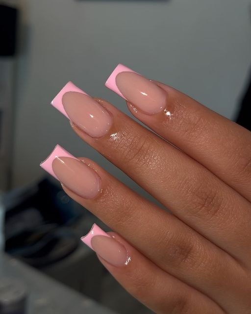 Chic Nail Design: Stylish Soft Pink and Nude with Vibrant French Twist Accent.