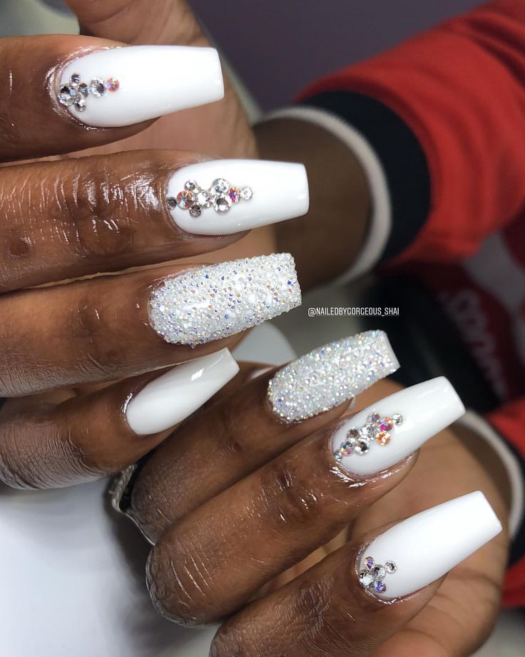 Sophisticated White Nail Design with Sparkling Accents and Intricate Rhinestones.