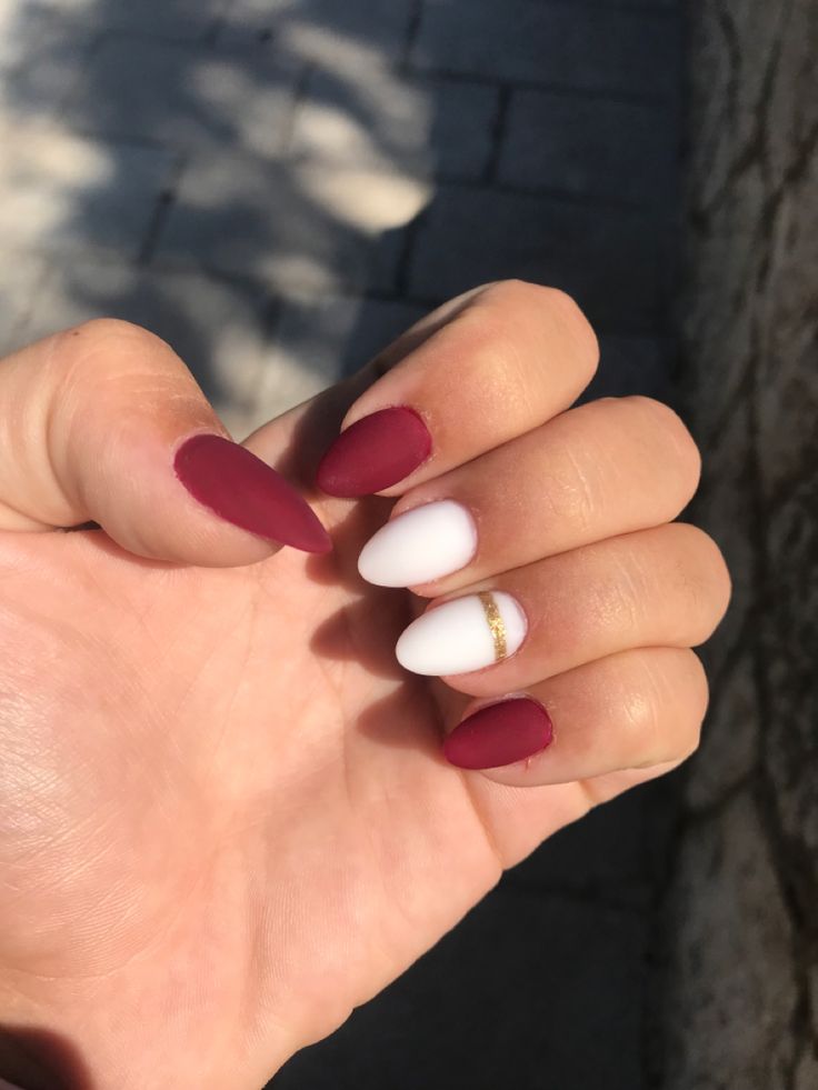 Sophisticated Nail Design: Deep Burgundy and Pristine White with Gold Accents.