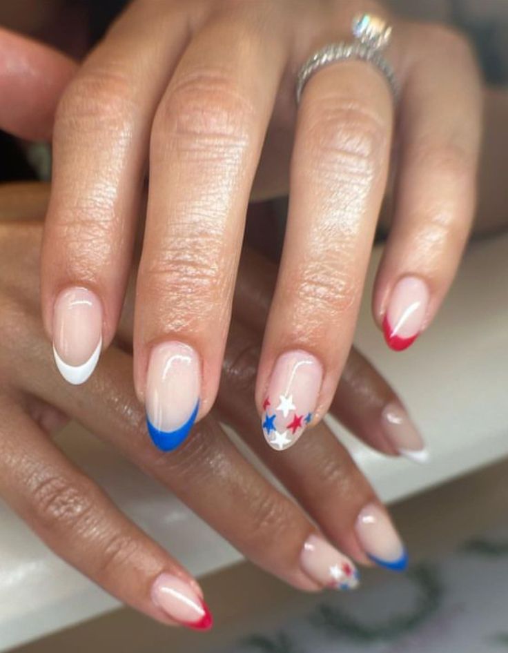 Patriotic Playful Nail Design: Chic French Tips with Bold Red, White, and Blue Accents and a Star Detail.