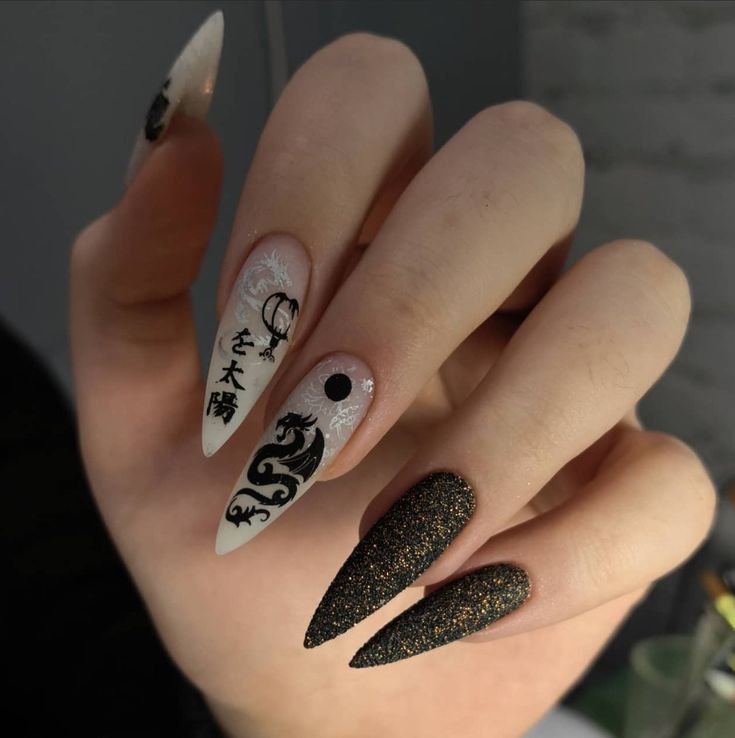 Dramatic Black and White Elongated Nail Design with Intricate Patterns and Sparkling Accents.