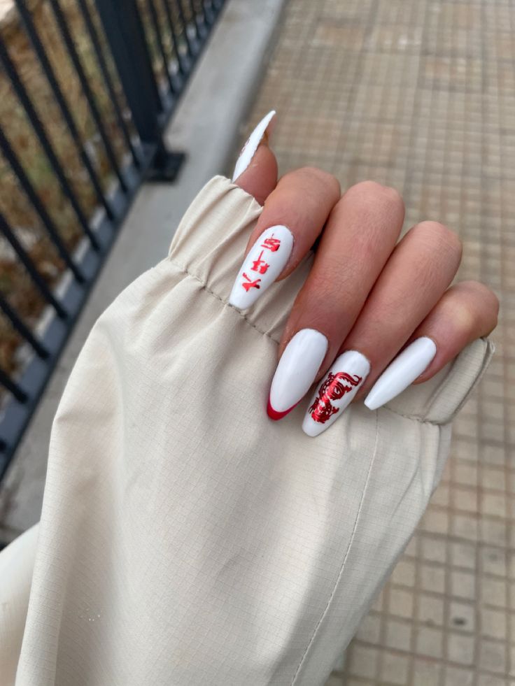 Chic Elongated White Nails with Bold Red French Tips and Intricate Graphics