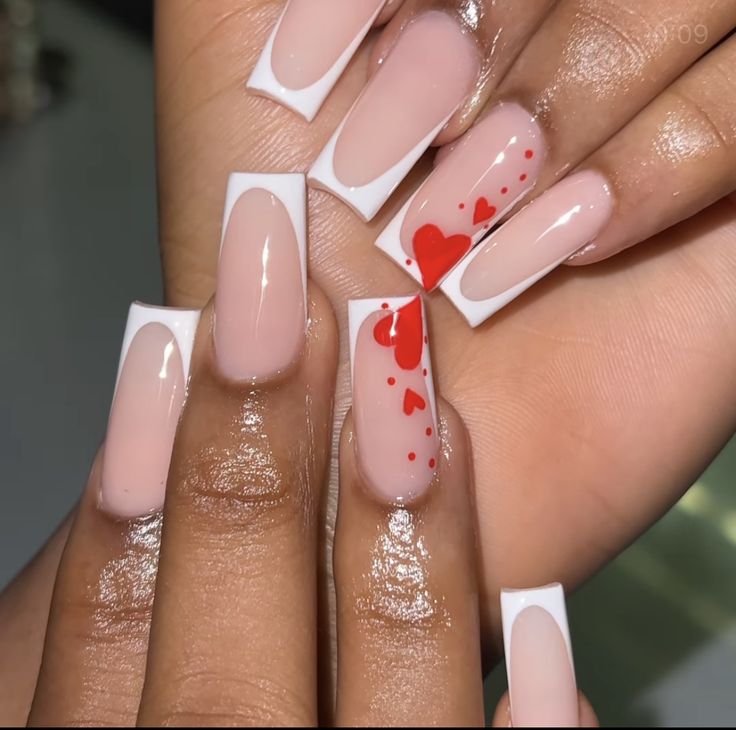 Playful and Elegant Nude Acrylic Nails with White Tips and Red Heart Accents.