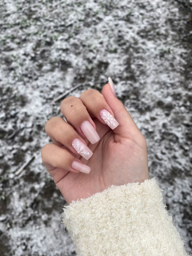 Sophisticated Winter-Inspired Nail Design with Soft Pink Base and Delicate White Leaf Patterns.