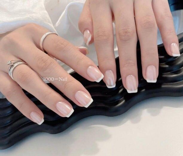 Sophisticated French Tip Manicure: Elegance in Simplicity with Nude Base and Crisp White Tips.