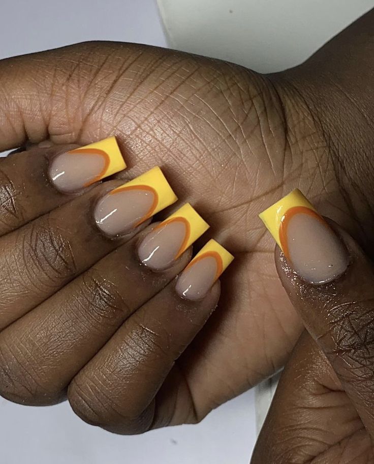 Vibrant Nude Base with Bold Yellow Tips and Warm Orange Accents for a Stylish Nail Design.