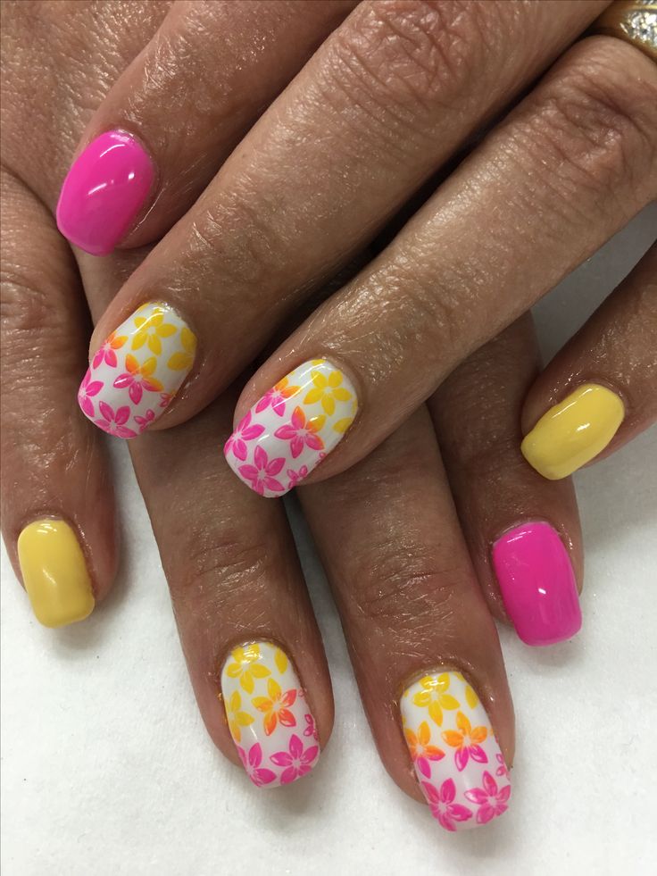 Vibrant Floral Nail Design: Cheerful Patterns in Pink, Yellow, and White for Festive Occasions.