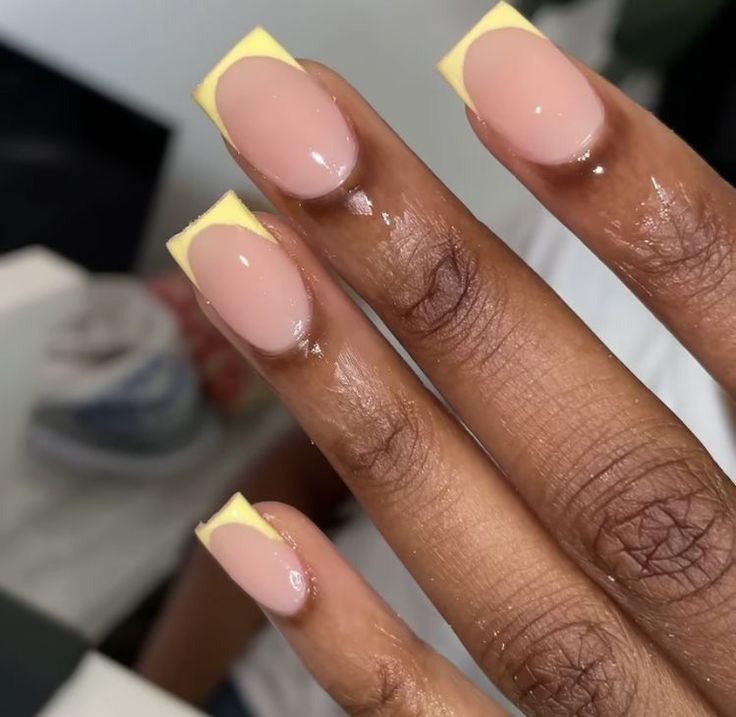 Chic Nail Design: Elegant Nude Base with Vibrant Yellow Tips and Modern Shape Blend.