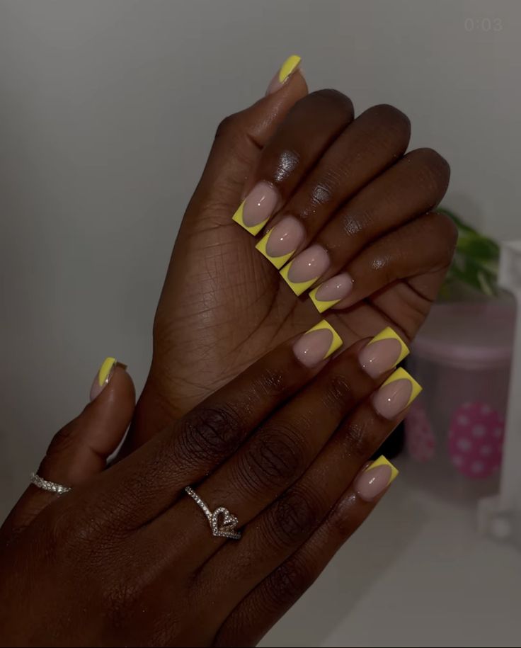 Trendy Chic Nail Design: Elegant Nude Base with Vibrant Yellow Tips.