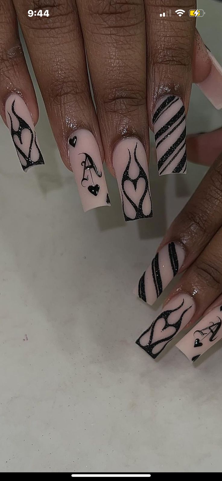 Chic Black and Nude Nail Design with Intricate Patterns for Stylish Statements.