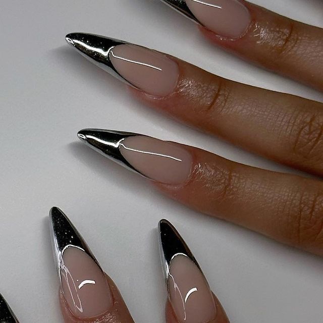 Chic Stiletto Nails: Nude Base with Striking Metallic Tips and Playful Curved Details.