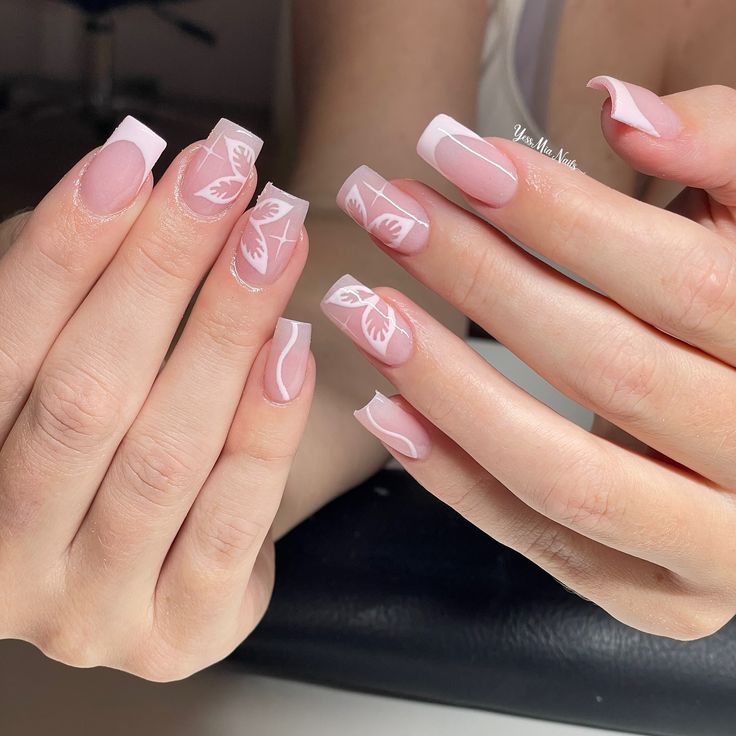 Chic Soft Pink Nail Design with French Tips and Delicate White Leaf Patterns.