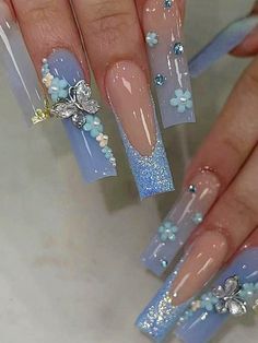 Sophisticated Nail Design: Soft Blue and Nude Ombre with Floral Accents and Gem Highlights.