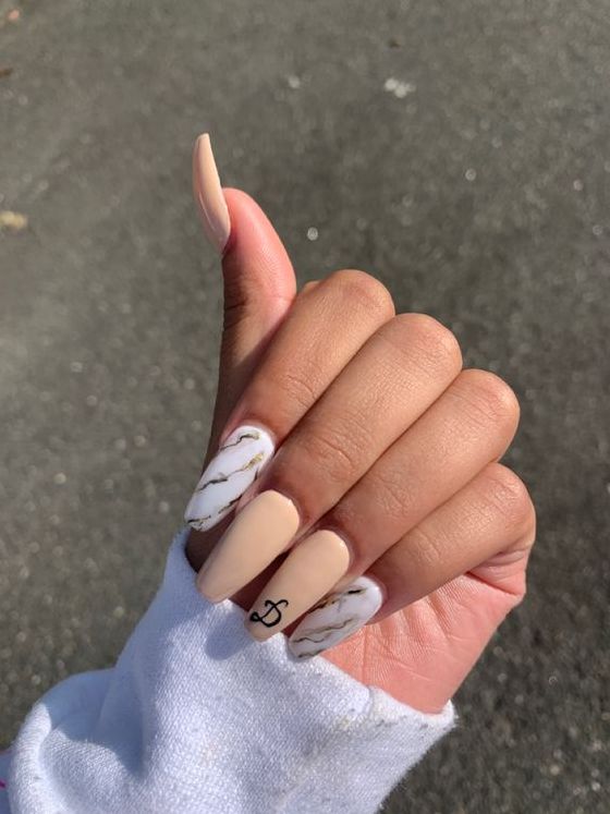 Sophisticated Nail Design: Soft Beige Base with Marble Accents and Minimalist Charm