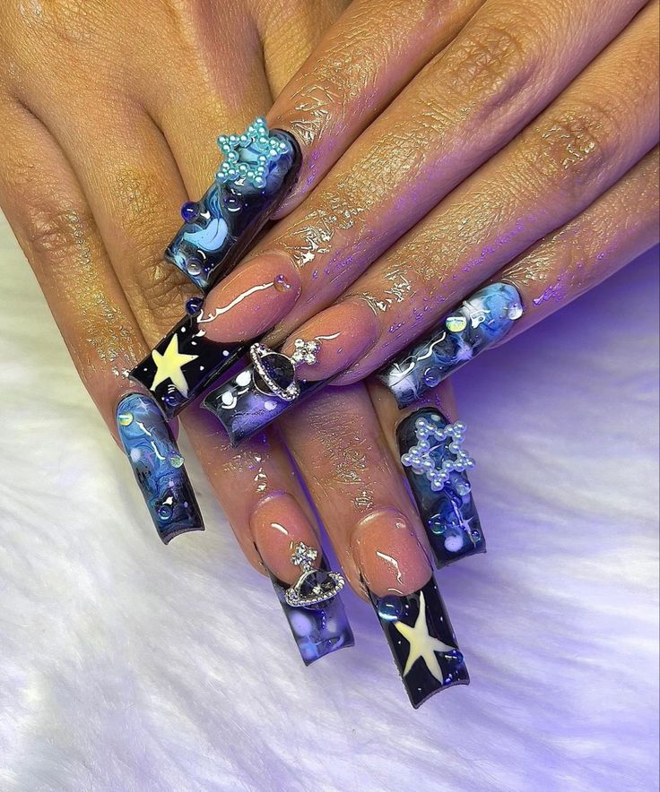 Bold Galactic-Themed Nail Design with Blue and Black Hues, Stars, and 3D Embellishments.