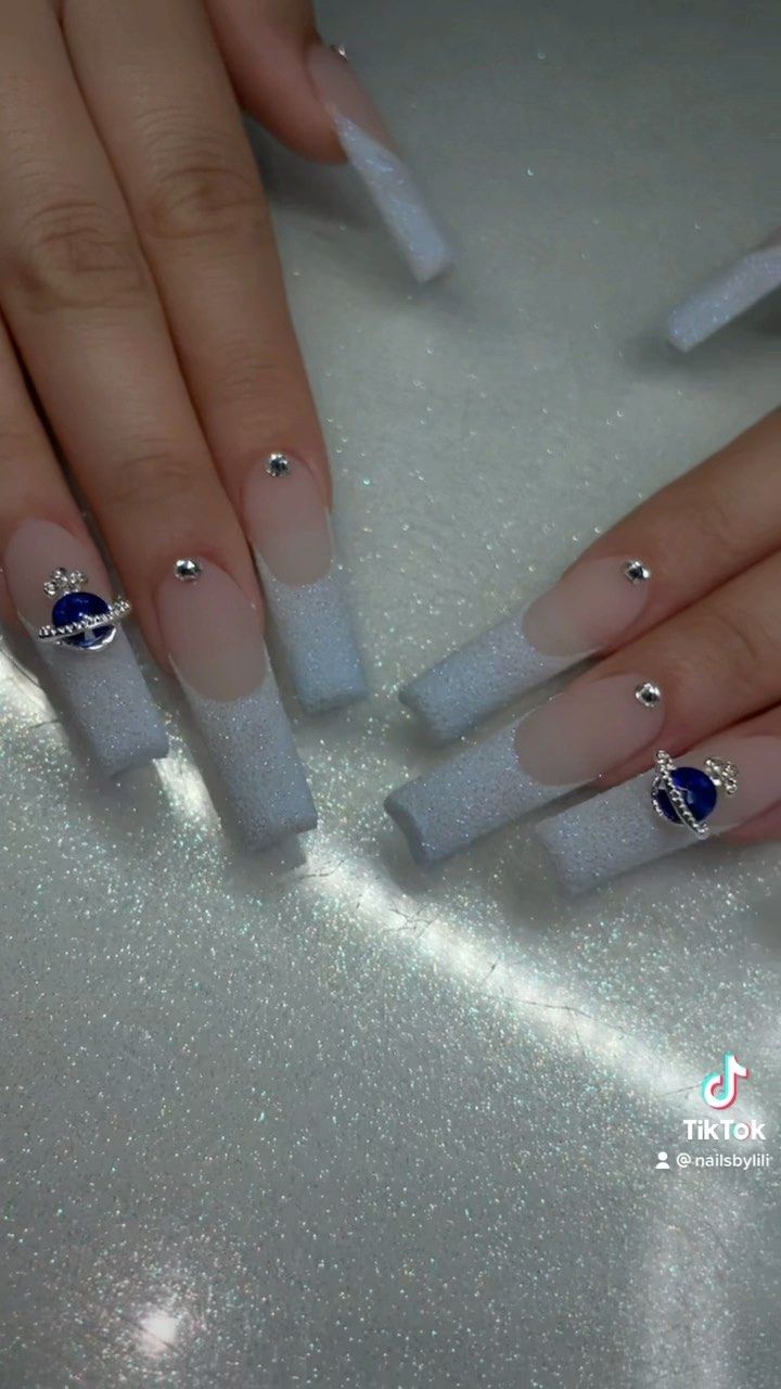 Stunning Glittery Ombre Nails with Pale Blue Gradient and Elegant Embellishments.