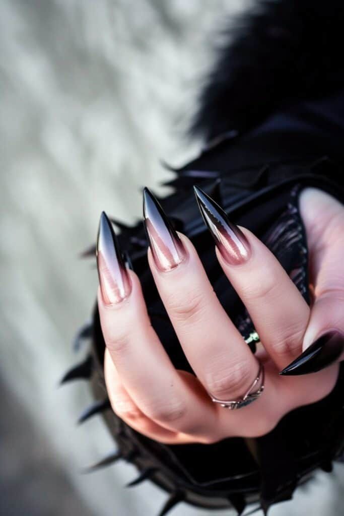 Striking Ombre Stiletto Nail Design with Black Tips and Metallic Rose Hue.