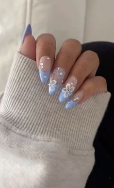 Elegant Pastel Blue and Nude Ombre Nails with Floral Designs for a Fresh Spring Aesthetic.