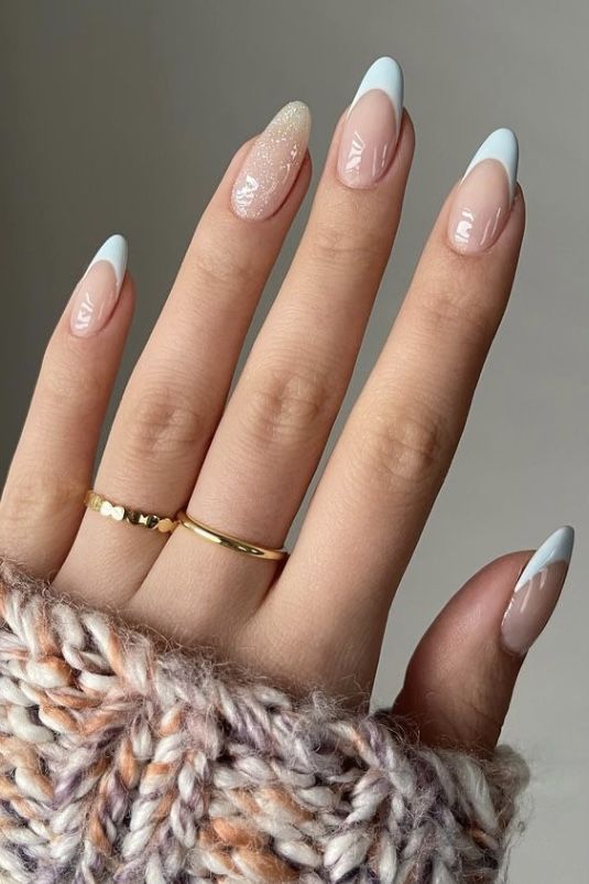 Chic and Sophisticated Nail Design: Soft Nude with Striking Baby Blue Tips and a Glitter Accent.