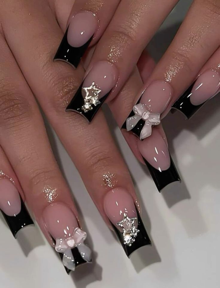 Chic Black-Tipped Nude Nails with Glitter and Bow Accents for Elegant Style.