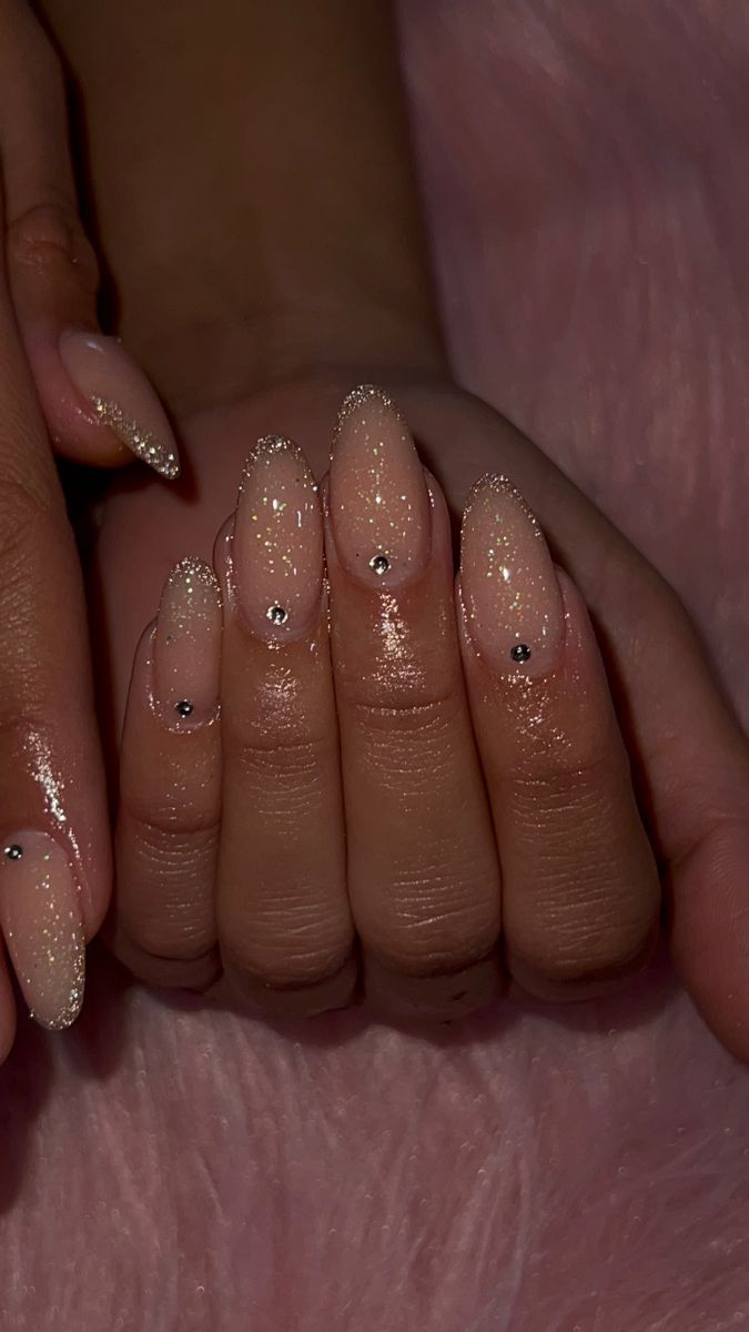 Chic Sparkling Nude Nail Design with Gradient Shimmer and Rhinestone Accents.