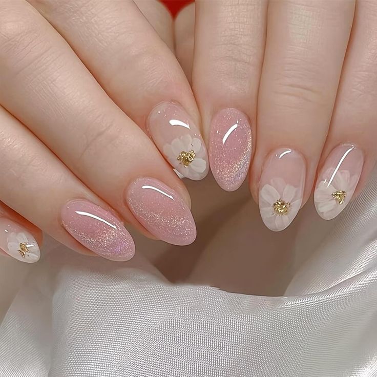 Elegant Floral Nail Design with Soft Pink Hues, Glitter, and Gold Accents.