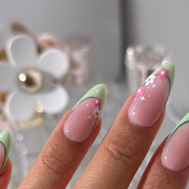 Charming Spring Nail Design: Soft Pink Base with Delicate Green Tips and Floral Accents.