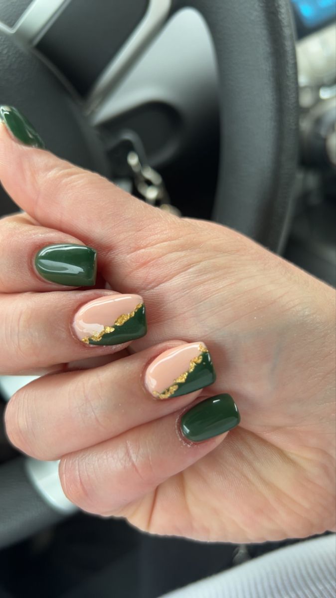 Elegant Nail Design: Deep Green and Soft Nude with Gold Accents and Wave Patterns.