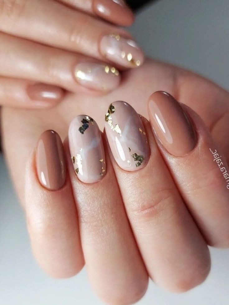 Stylish Nail Design: Neutral Tones with Gold Accents for a Sophisticated Look.