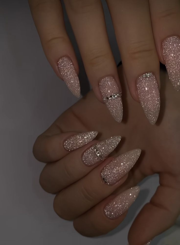 Elegant Glittering Nail Design with Rhinestone Accents and Soft Nude Tones.