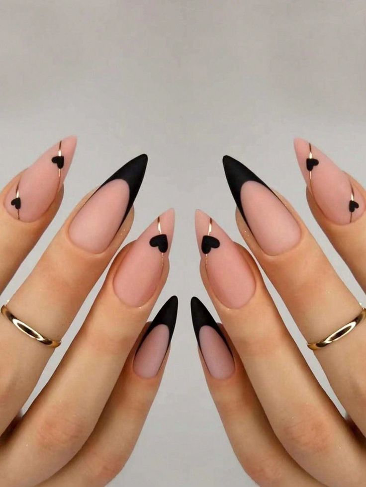 Sophisticated Nail Design: Matte Nude and Glossy Black Tips with Playful Heart Accents.