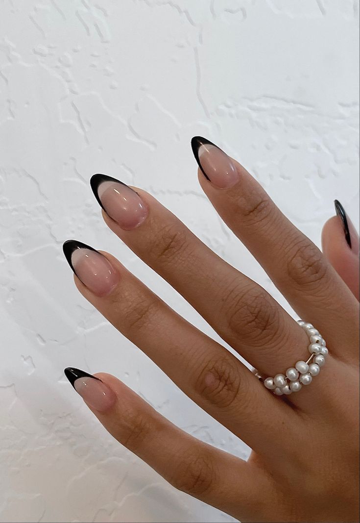 Chic French Manicure: Elegant Nude Base with Striking Black Tips and Pearl Ring Accent