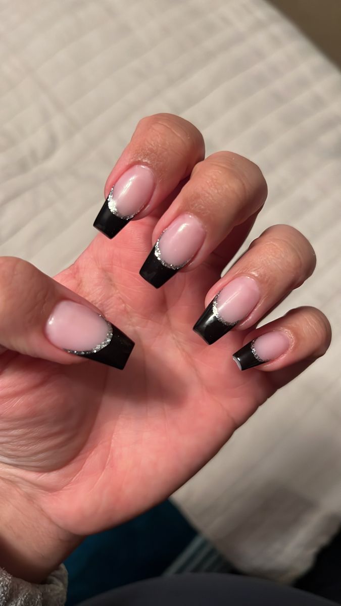 Elegant French Tip Nail Design with Black Tips and Silver Accents on Nude Base.