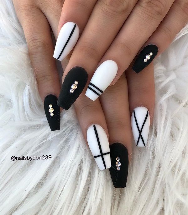 Chic Nail Design: Bold Matte Black and Crisp White with Geometric Lines and Rhinestones.