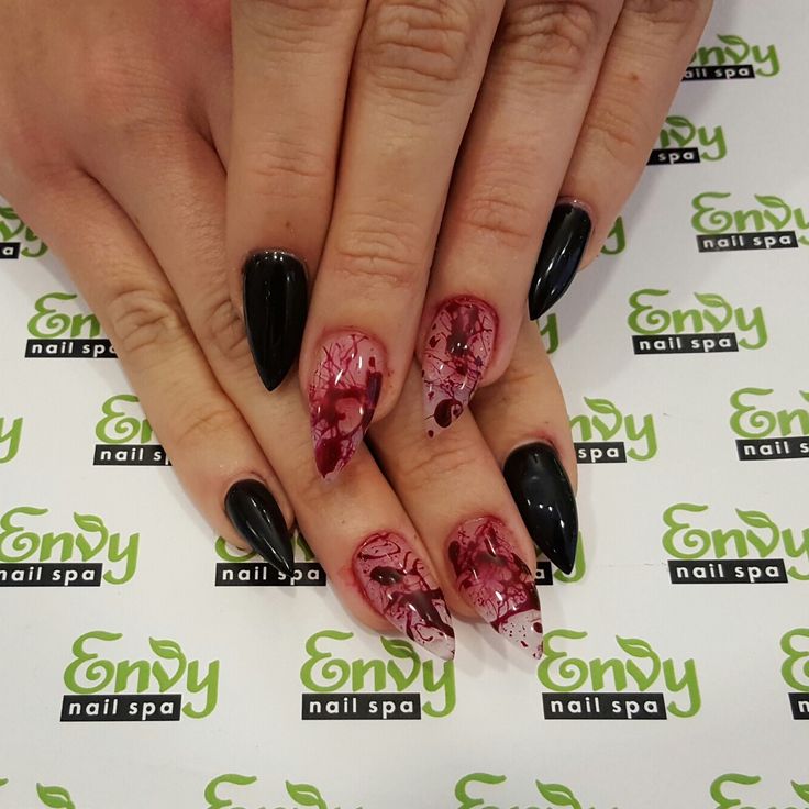 Elegant and Bold Nail Design: Glossy Black with Vivid Red Splatter Effect