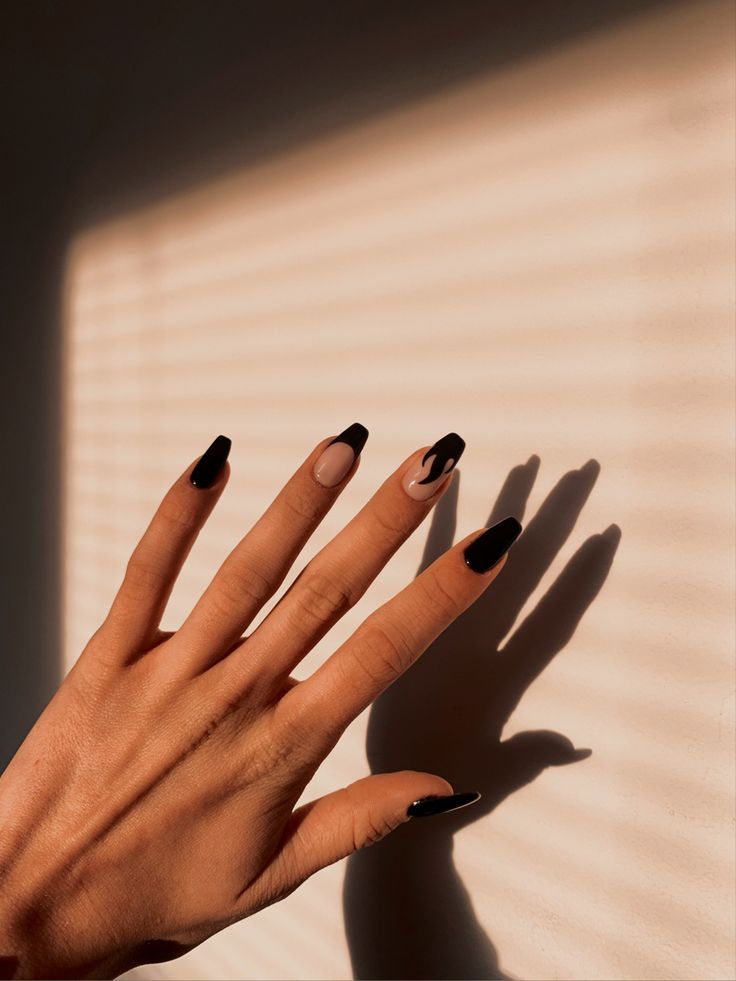 Chic Almond-Shaped Nail Design with Black and Nude Swirls Enhanced by Sunlight Shadows.