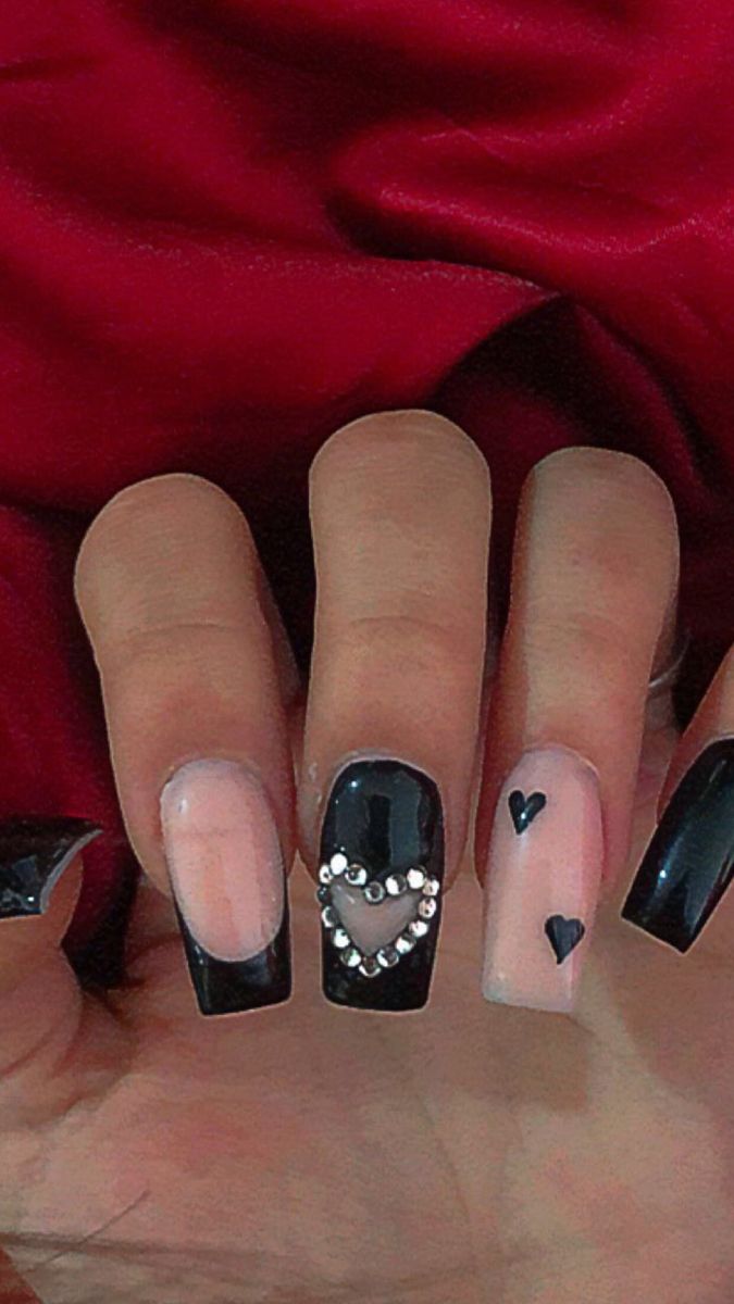 Trendy Black and Nude Nail Design with Rhinestone and Painted Heart Embellishments