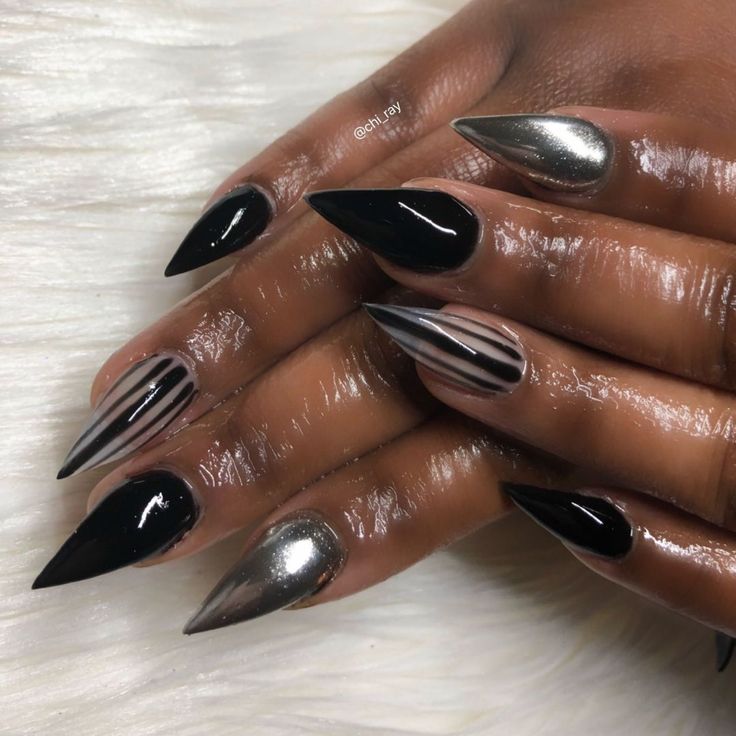 Chic Stiletto Nail Design with Glossy Black, Metallic Silver, and Nude Hues for a Bold Look.