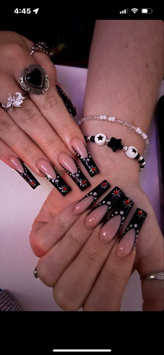 Elegant Nude and Black Tip Nail Design with Bold Red and White Star Embellishments