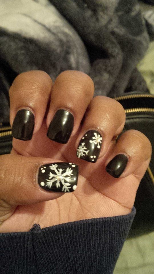 Chic Winter Nail Design: Black Base with Delicate White Snowflakes