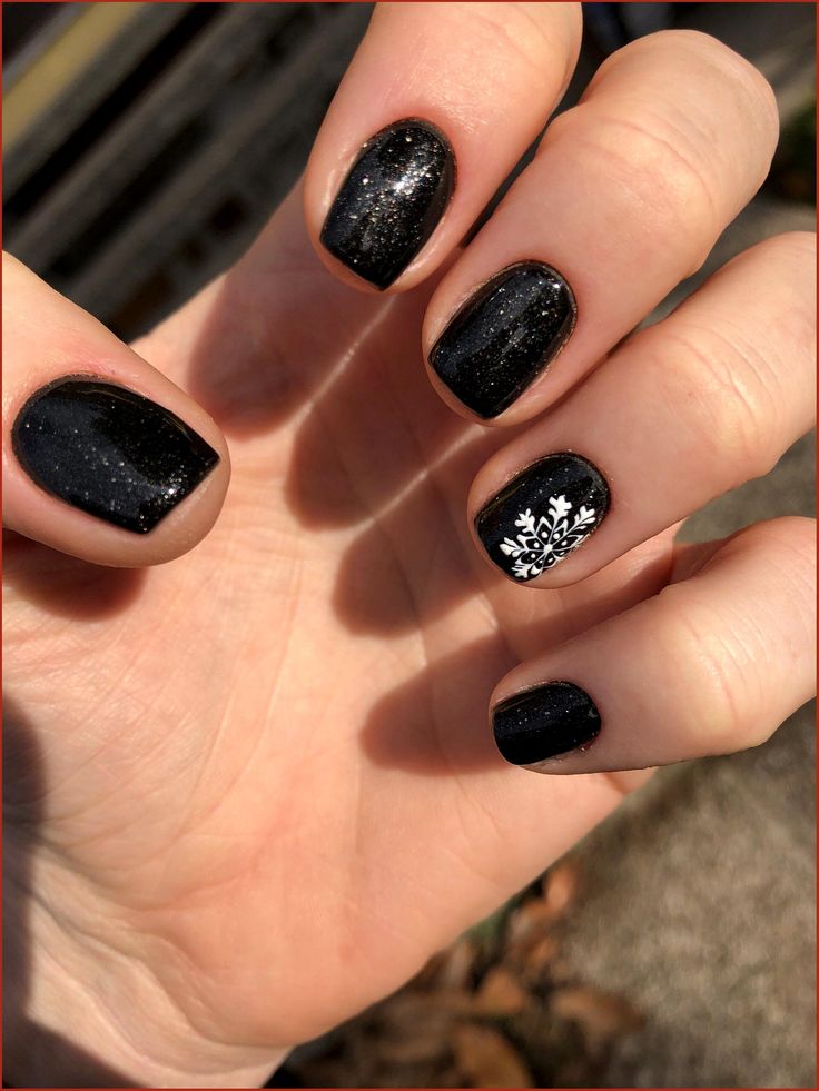 Chic Black Nail Design with Shimmer and Festive Snowflake Accent.